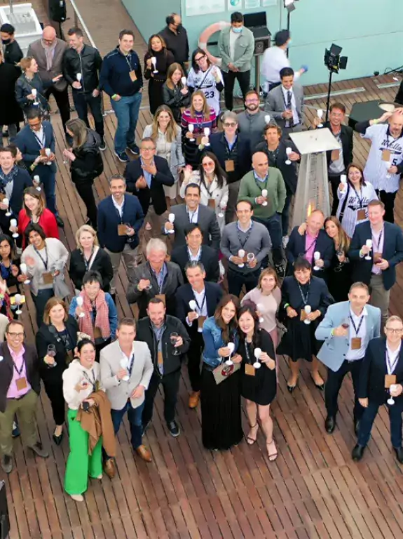 Group of people holding champagne glasses during an event, drone shot