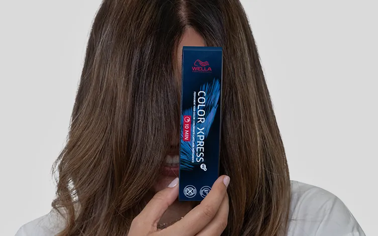 WellaCompany-ColorXpress-Card.jpg Smiling brunette with her face covered by hair presents Color Xpress hair dye