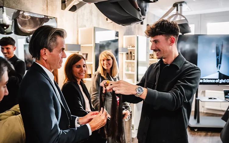 WellaCompany-deib-OurTrainingAndEducation-Card.jpg group of elegant people looking at hair color samples in a hair salon full of professional equipment