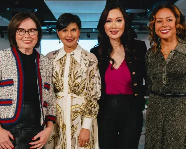 Four elegant, smiling women in an office space