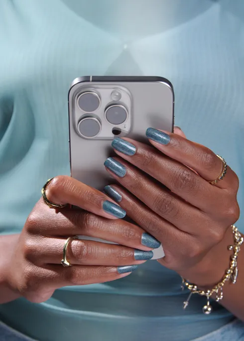 woman in blue shirt browsing news on smartphone